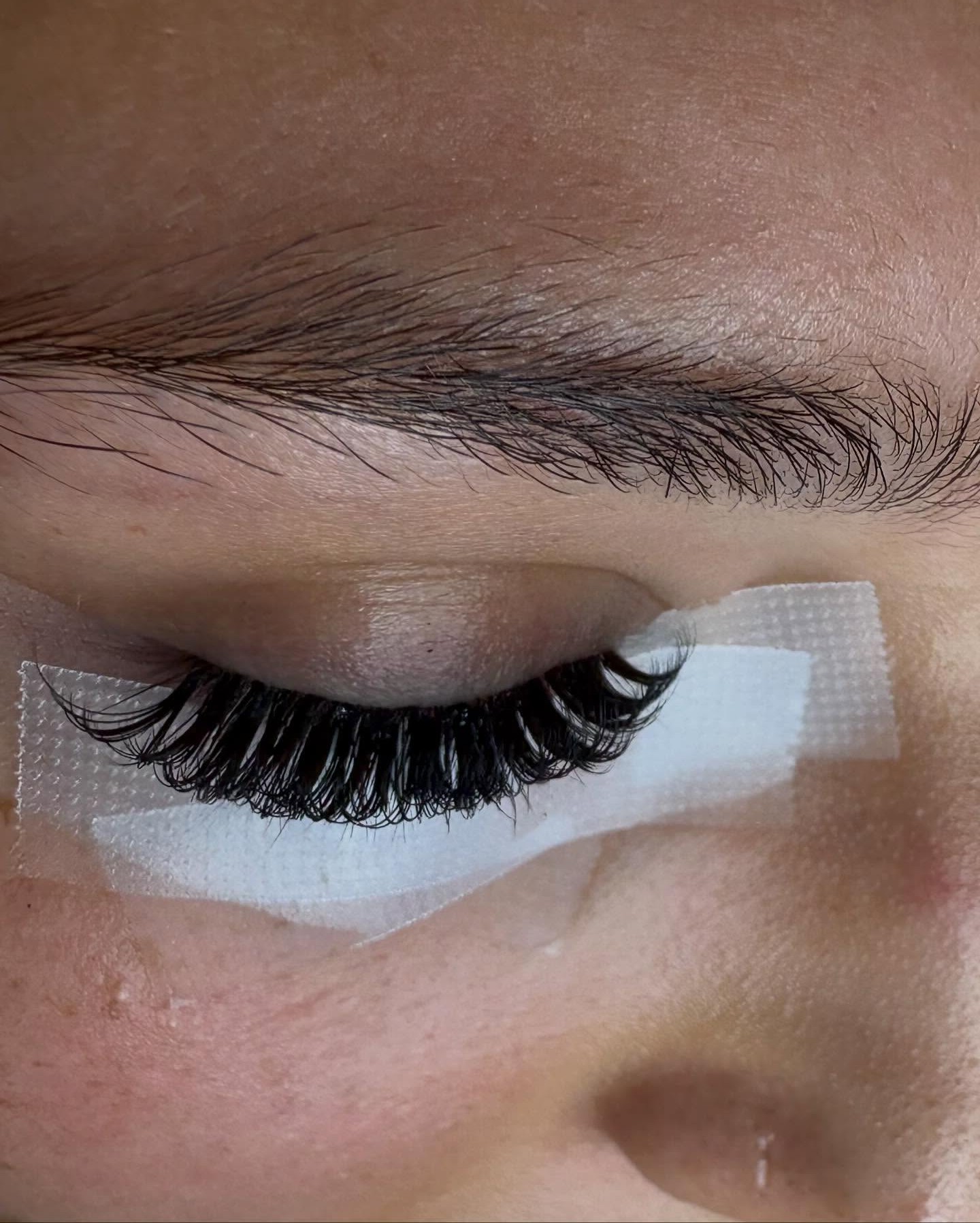Een net gezette set wimperextensions, de onderwimpers nog afgeplakt