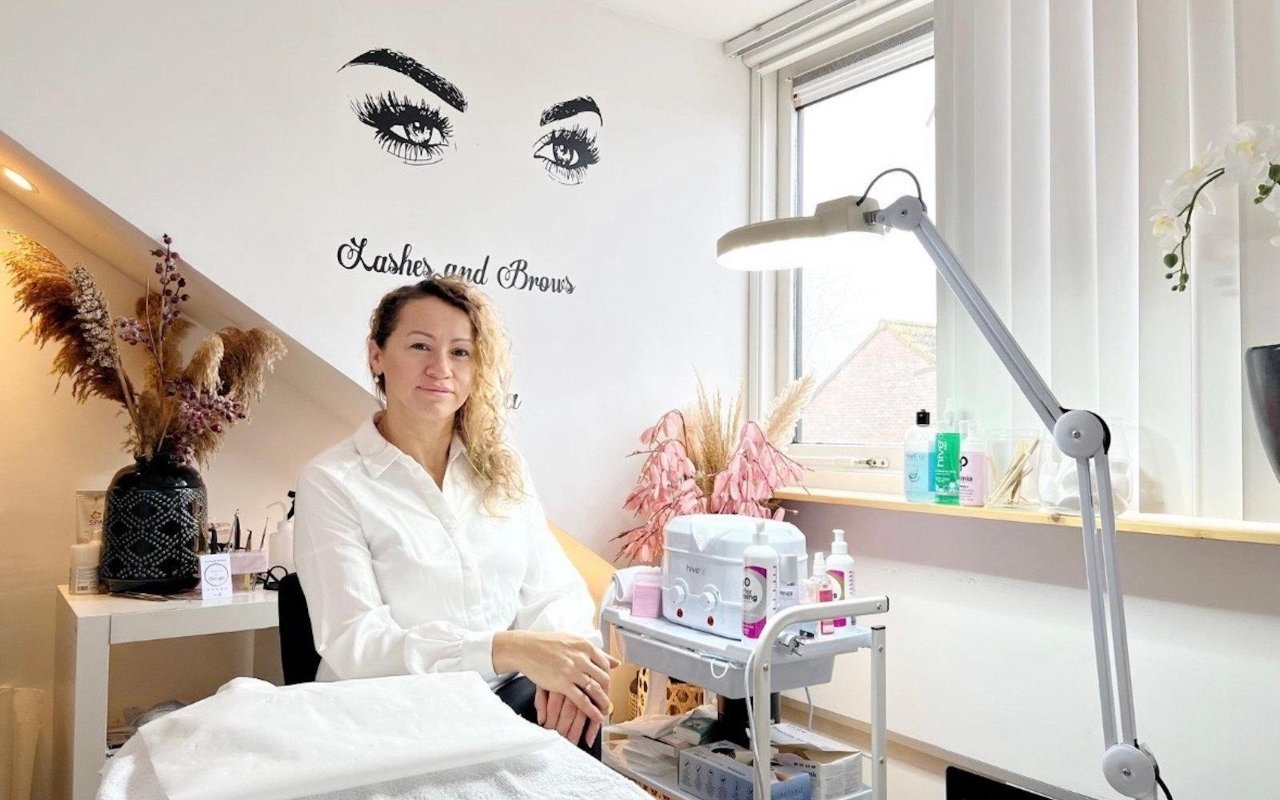 Maria in haar behandelruimte, naast het behandelbed en de lamp