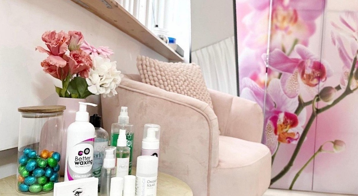 De roze fauteuil met verzorgingsproducten en orchideeën