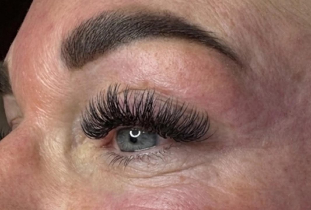Een gezette set wimperextensions onder een verzorgde wenkbrauw